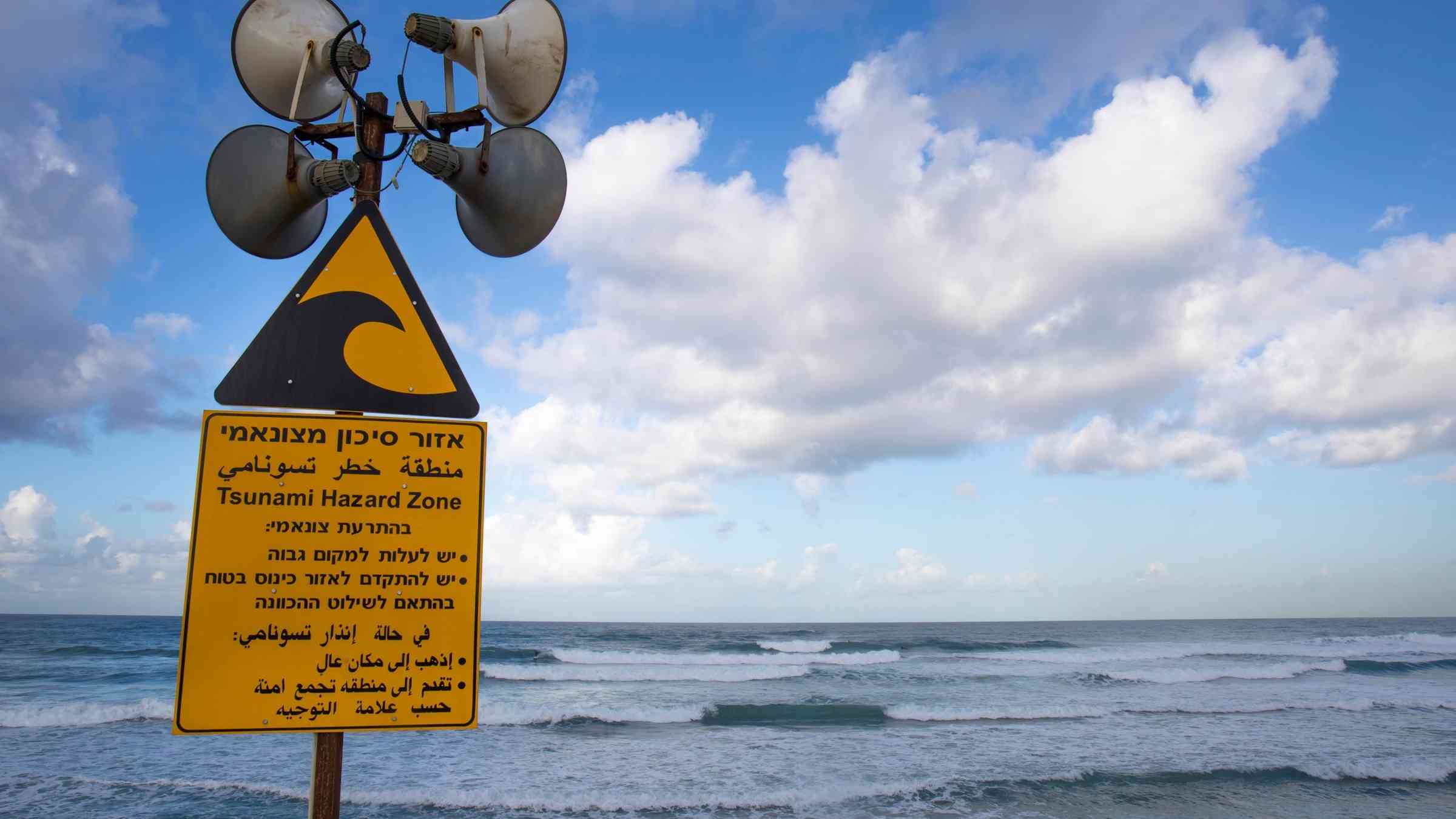 a hazard sign on a beach in Tel Aviv with sirens to facilitate early warnings systems