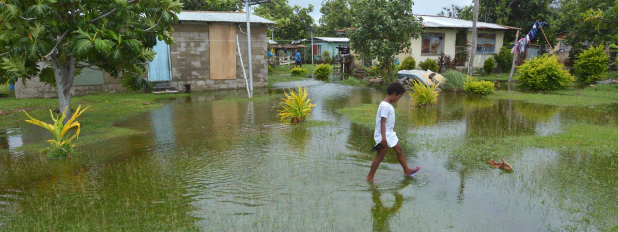 Indigenous Fijian girl walking on flooded land in Fiji