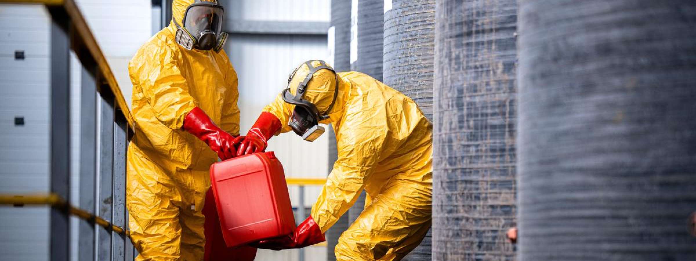 Chemical worker carrying canisters with hazardous materials